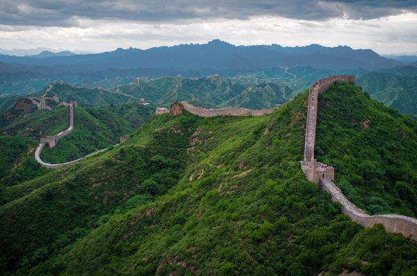 The Great Wall of China winding over green mountain ridges The Great Wall of China winding over green mountain ridges