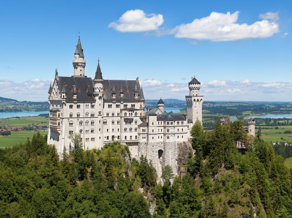 Neuschwanstein Castle above the Bavarian forest in autumn Neuschwanstein Castle above the Bavarian forest in autumn